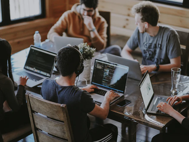 A team working together on laptops around one table